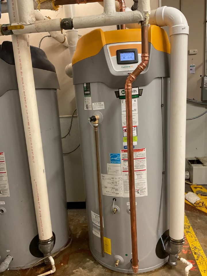 High-efficiency commercial water heater installed in a Batavia mechanical room, with copper supply lines and a digital control head