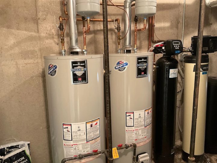 Two Bradford White tank water heaters installed side by side with copper supply lines